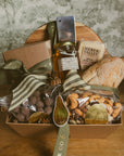 Gift basket with food items on a wooden surface