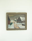 Framed painting of a snowy landscape with buildings on a white wall