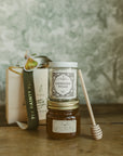 Jar of lavender sugar and honey with a book and spoon on a wooden surface
