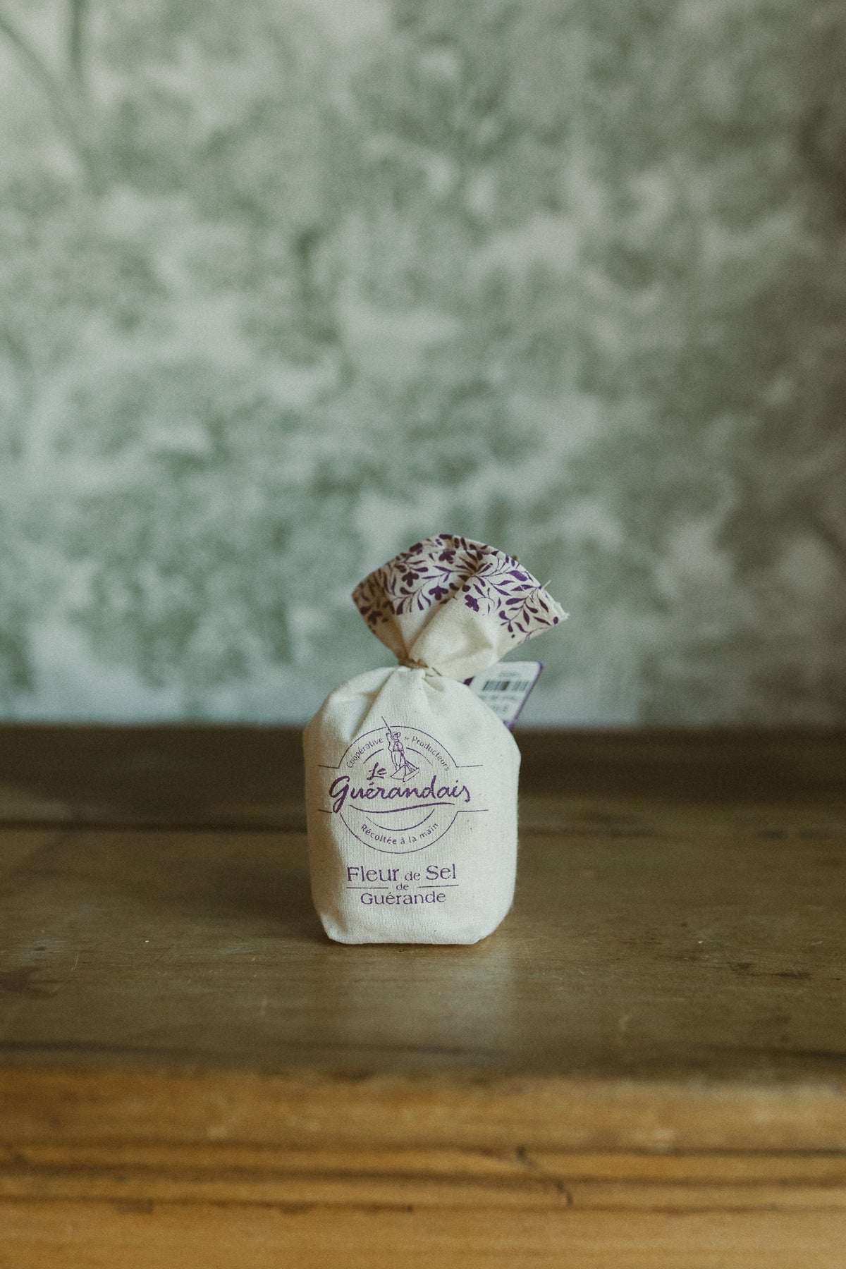 Le Guérandais Fleur de Sel de Guérande in a cotton pouch tied with purple floral fabric