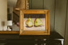 Original oil still life of two green pears against a deep plum background by Chantry Brewer, in a carved gold frame