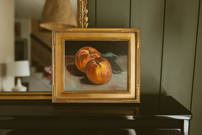 Original oil still life of two ripe red and gold apples on a dark background by Chantry Brewer, in a carved gold frame