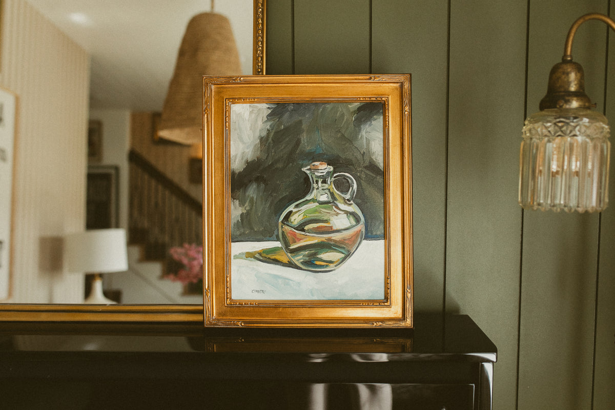Original oil still life of a corked glass olive oil cruet on a charcoal background by Chantry Brewer, in a carved gold frame