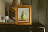 Original oil painting of a single green pear on a blush pink tabletop by Chantry Brewer, in a carved gold frame