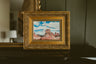 Original oil painting of Monument Valley red buttes under a cloudy blue sky by Chantry Brewer, in an ornate gold frame